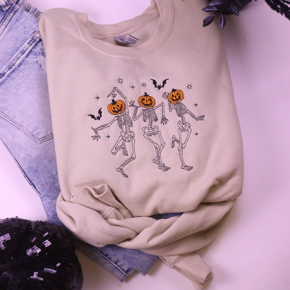 Neutral Halloween crewneck sweatshirt featuring dancing skeletons with orange jack-o'-lantern pumpkin heads and bats