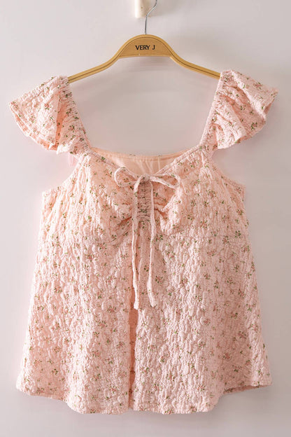 Blushing Prairie floral babydoll top available in blush and white with ruffle flutter sleeves and feminine tie-front neckline.