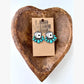 Turquoise western drop earrings featuring playing card designs and turquoise-inspired stone accents displayed on a rustic heart-shaped tray