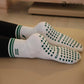 White and green Pilates grip socks with striped ribbed cuffs, embroidered chili pepper detail and green non-slip grips on the soles.