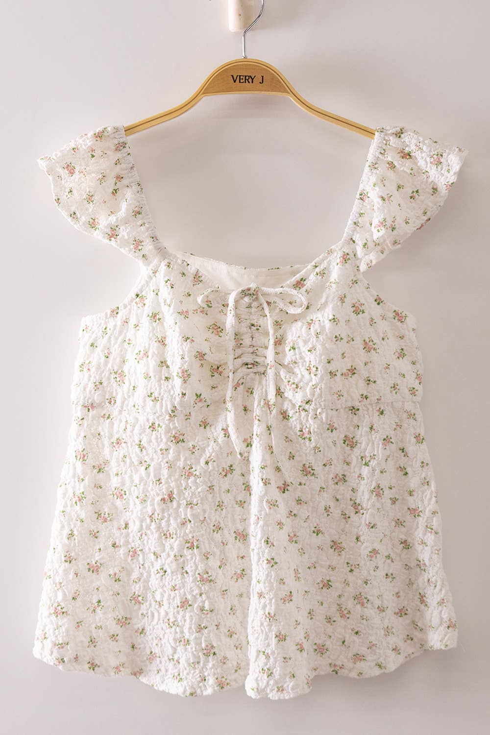 Blushing Prairie floral babydoll top available in blush and white with ruffle flutter sleeves and feminine tie-front neckline.