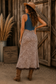 Women's cheetah print maxi skirt featuring ruched detailing, brown lace splicing and a front slit styled with cowboy boots and a denim vest.