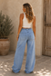 Women's light wash denim cargo jeans with wide legs, utility pockets, drawstring waist and contrast seam detailing.
