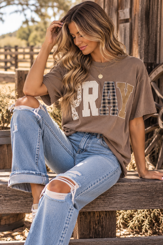 Neutral washed short sleeve PRAY graphic tee with oversized mixed-pattern patchwork lettering