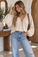 Women's neutral tie-front split neck blouse with long balloon sleeves styled with light wash denim
