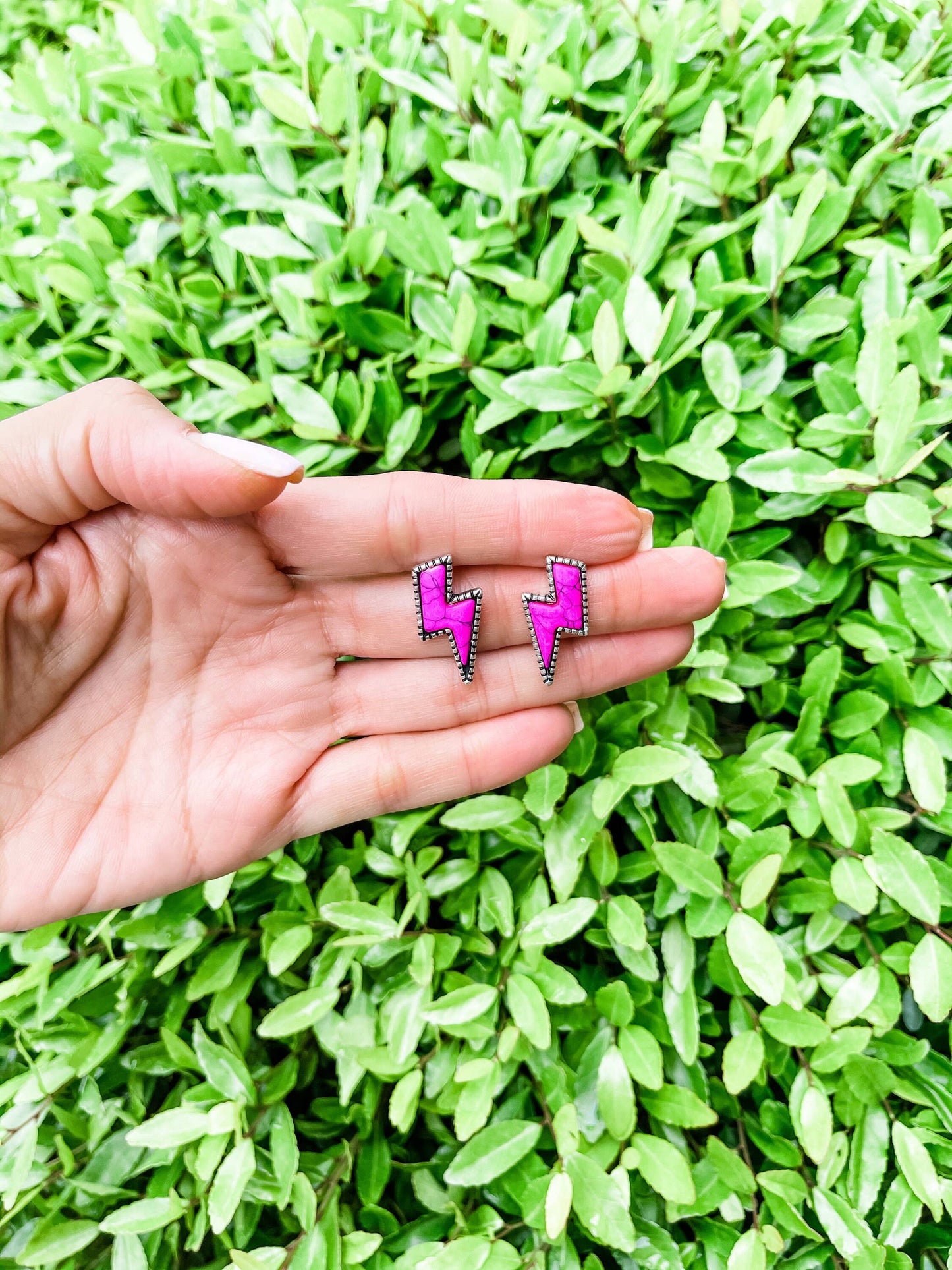 Western lightning bolt stud earrings with silver-tone detailing in pink, white and assorted colors displayed on boutique jewelry cards