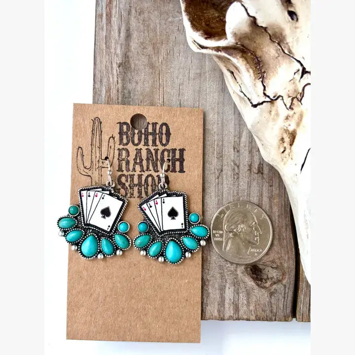 Turquoise western drop earrings featuring playing card designs and turquoise-inspired stone accents displayed on a rustic heart-shaped tray